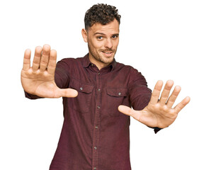 Sticker - Young hispanic man wearing casual clothes doing stop gesture with hands palms, angry and frustration expression