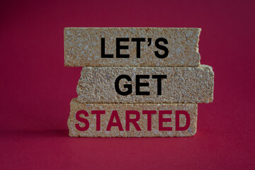 Wall Mural - Let's get started symbol. Motivational quote Let us get started on brick blocks. Beautiful red background. Business concept.