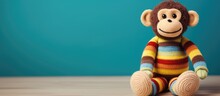 Cute Monkey Toy With Fuzzy Brown Body, Ivory Face, Hands, And Feet, Wearing A Colorful Striped Sweater.