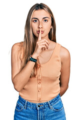 Poster - Hispanic young woman wearing casual summer shirt asking to be quiet with finger on lips. silence and secret concept.