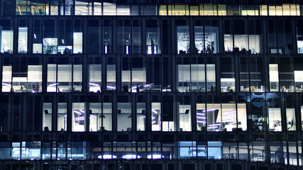 Wall Mural - Fragment of the glass facade of a modern corporate building at night. Modern glass office  in city. 