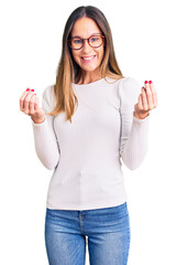Wall Mural - Beautiful brunette young woman wearing casual white sweater and glasses doing money gesture with hands, asking for salary payment, millionaire business