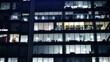 © Grand Warszawski - Fragment of the glass facade of a modern corporate building at night. Modern glass office  in city. Big glowing windows in modern office buildings at night, in rows of windows light shines.