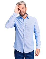 Wall Mural - Young handsome blond man wearing elegant shirt doing ok gesture with hand smiling, eye looking through fingers with happy face.