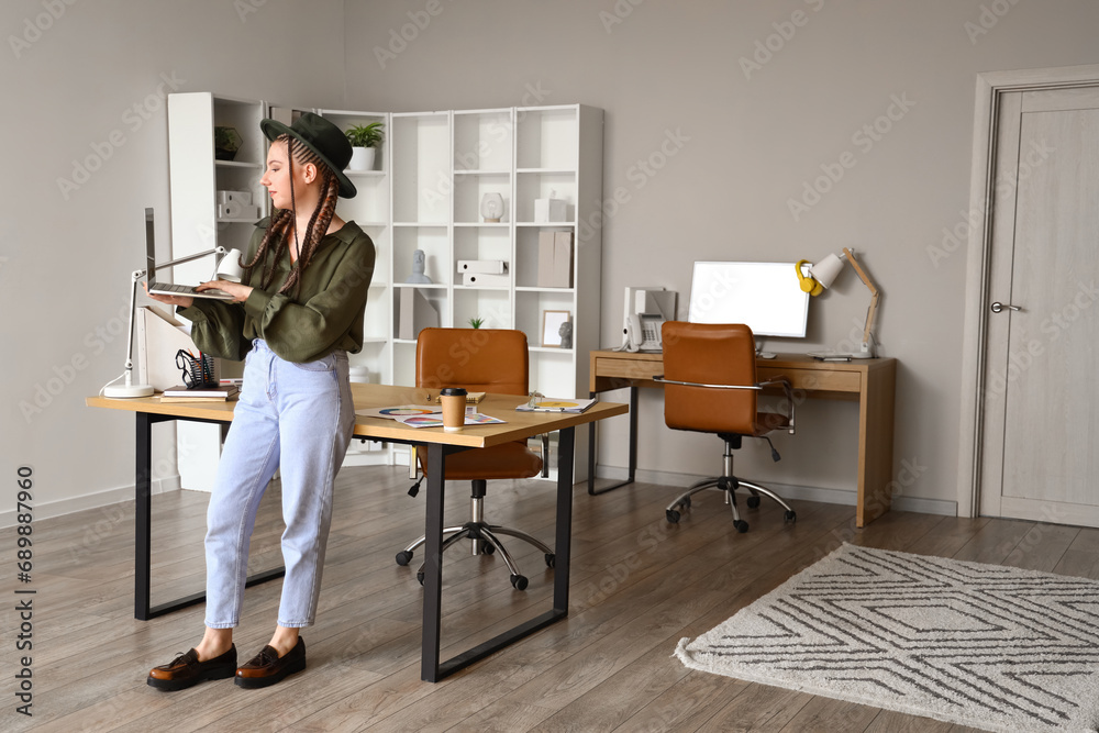 Female designer working with laptop in office