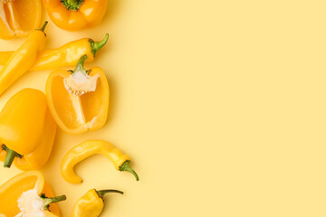 Wall Mural - Different fresh peppers on yellow background