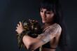 Photo of brunette woman holding yellow anaconda in shadows
