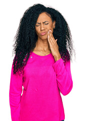 Wall Mural - Middle age african american woman wearing casual clothes touching mouth with hand with painful expression because of toothache or dental illness on teeth. dentist