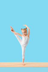 Poster - Cute little girl doing gymnastics on mat against blue background