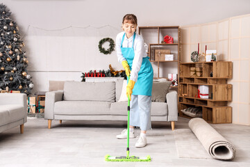 Poster - Young janitor mopping floor in messy living room after New Year party