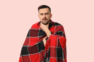 Poster - Sick young man with plaid on pink background