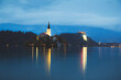 Evening twilight view of Pilgrimage Church of the Assumption of Maria Bled Castle lit up at Lake Bled, Slovenia in the Julian Alps.