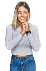 Wall Mural - Beautiful blonde woman wearing casual clothes laughing nervous and excited with hands on chin looking to the side