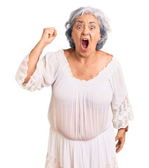 Sticker - Senior woman with gray hair wearing bohemian style angry and mad raising fist frustrated and furious while shouting with anger. rage and aggressive concept.