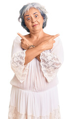 Sticker - Senior woman with gray hair wearing bohemian style pointing to both sides with fingers, different direction disagree