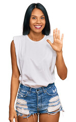 Wall Mural - Young african american woman wearing casual clothes showing and pointing up with fingers number five while smiling confident and happy.