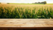 © TEERAPONG - Corn field wooden brown table top with blur background of corn field. Exuberant image.