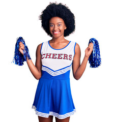 Poster - Young african american woman wearing cheerleader uniform holding pompom with a happy and cool smile on face. lucky person.