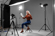 Casting call. Emotional woman with script sitting on chair and performing in front of camera in studio