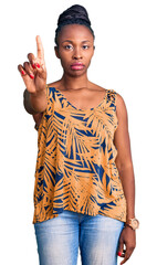 Wall Mural - Young african american woman wearing casual clothes pointing with finger up and angry expression, showing no gesture