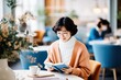 © evgenia_lo - A portrait of a beautiful and happy young Asian woman enjoys reading a book at a cafe. Lifestyle concept