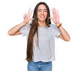 Poster - Young hispanic girl wearing casual white t shirt showing and pointing up with fingers number eight while smiling confident and happy.