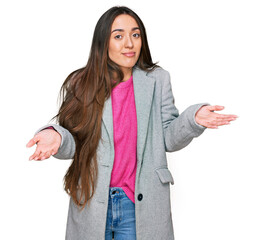 Poster - Young hispanic girl wearing business clothes clueless and confused expression with arms and hands raised. doubt concept.