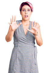 Canvas Print - Young beautiful woman with pink hair wearing casual clothes afraid and terrified with fear expression stop gesture with hands, shouting in shock. panic concept.