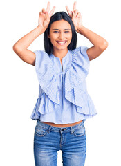 Poster - Young beautiful latin girl wearing casual clothes posing funny and crazy with fingers on head as bunny ears, smiling cheerful