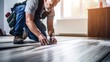 © Phoophinyo - A Construction worker installing laminate flooring, room decoration design, professional technician, laminate background.