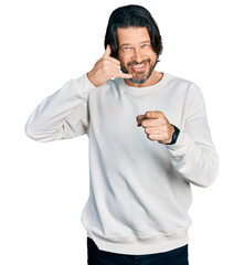 Poster - Middle age caucasian man wearing casual clothes smiling doing talking on the telephone gesture and pointing to you. call me.