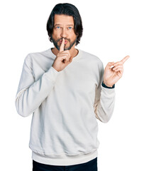 Poster - Middle age caucasian man wearing casual clothes asking to be quiet with finger on lips pointing with hand to the side. silence and secret concept.