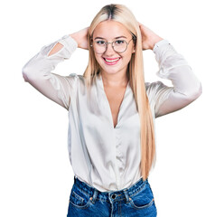 Wall Mural - Beautiful blonde woman wearing elegant shirt and glasses relaxing and stretching, arms and hands behind head and neck smiling happy