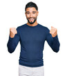 © Krakenimages.com - Young man with beard wearing casual blue winter sweater screaming proud, celebrating victory and success very excited with raised arms
