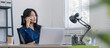 © chartchai - Young happy asian woman talking on mobile phone, relaxing while working at co-workspace.