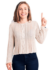 Poster - Young beautiful blonde woman wearing casual sweater showing and pointing up with finger number one while smiling confident and happy.