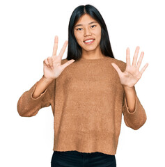 Poster - Beautiful young asian woman wearing casual winter sweater showing and pointing up with fingers number eight while smiling confident and happy.