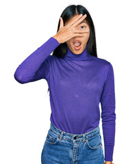 Sticker - Beautiful young asian woman wearing casual clothes peeking in shock covering face and eyes with hand, looking through fingers with embarrassed expression.