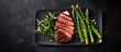© 2rogan - Top view of gray cast iron plate with sliced green asparagus, parmesan cheese, and dry-aged Wagyu sirloin beef steak