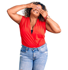 Wall Mural - Young african american plus size woman wearing casual style with sleeveless shirt covering eyes with hands smiling cheerful and funny. blind concept.