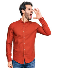 Sticker - Young hispanic man wearing casual clothes shouting and screaming loud to side with hand on mouth. communication concept.