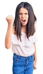 Sticker - Beautiful child girl wearing casual clothes angry and mad raising fist frustrated and furious while shouting with anger. rage and aggressive concept.