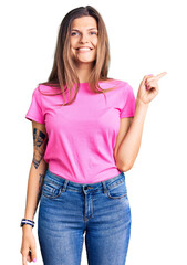 Poster - Beautiful caucasian woman wearing casual clothes with a big smile on face, pointing with hand finger to the side looking at the camera.