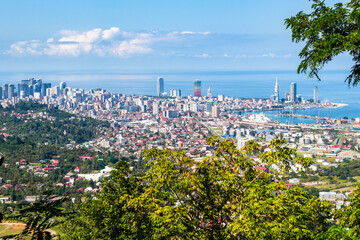 Canvas Print - travel to Georgia - green trees and view of Batumi city with suburb from Sameba hill on background on sunny autumn day