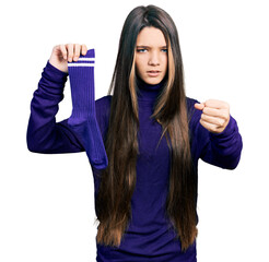 Wall Mural - Young brunette girl with long hair holding sporty sock annoyed and frustrated shouting with anger, yelling crazy with anger and hand raised