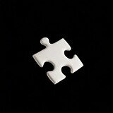 Fototapeta Dmuchawce - white jigsaw puzzle floating in the air, empty space for text, isolated black background.