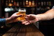 © primopiano - hand offering a light lager beer to another person