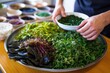 chef arranging seaweed salad for a food platter