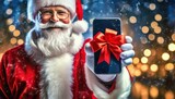 Fototapeta  - Święty Mikołaj trzymający smartfon przewiązany czerwoną wstążka