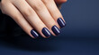 © Artinun - Glamour woman hand with navy blue nail polish on her fingernails. Navy nail manicure with gel polish at luxury beauty salon. Nail art and design. Female hand model. French manicure.